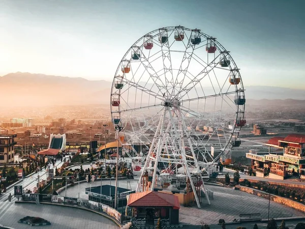 Sempre divertente vedere una ruota panoramica alta quando ci si avvicina al parco in vacanza piena di persone felici — Foto Stock