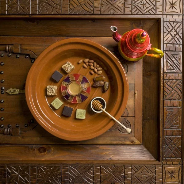 Stropní střela z kulatého dřevěného talíře s různými druhy sladkostí a ořechů — Stock fotografie