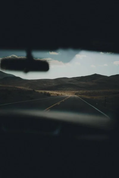 Άδειος αυτοκινητόδρομος σε μια έρημο με όμορφους λόφους στο παρασκήνιο από το εσωτερικό του αυτοκινήτου — Φωτογραφία Αρχείου