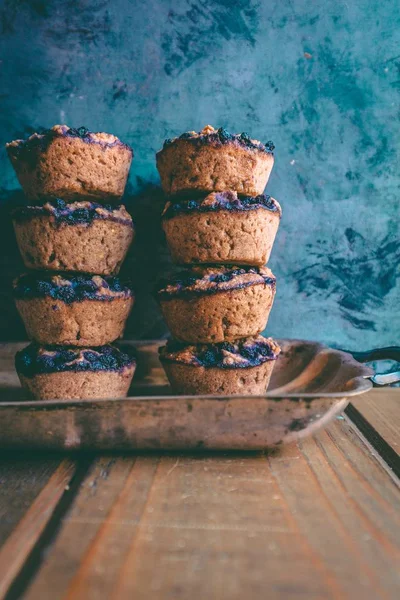 Closeup of delicious tasty blueberry muffins stacked on top of each other with a sky blue background — Stock Photo, Image