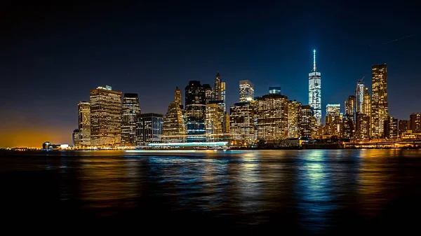 Schöne Weitwinkelaufnahme einer Stadt bei Nacht mit einem Boot — Stockfoto