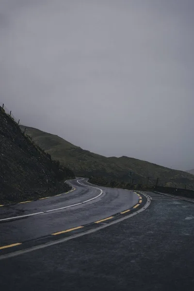 Két laned országút megy keresztül hegyek kettős sárga korlátozó vonalak — Stock Fotó