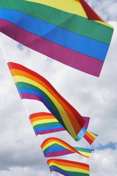 Pocos colorido gay orgullo ondeando banderas en una cuerda con el pacífico cielo en el fondo — Foto de Stock