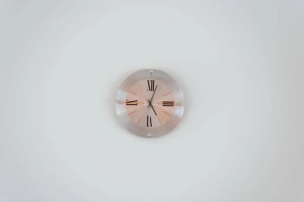 Amplio tiro de un reloj de pared de oro rosa en una pared blanca — Foto de Stock