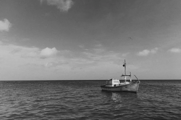 Foto em preto e branco de um grande barco flutuando no mar aberto — Fotografia de Stock