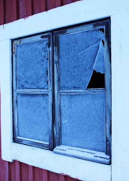 Egy négyzet alakú ablak függőleges Vértes egy törött üveggel, piros és fehér falon — Stock Fotó