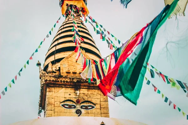 Buddhist prayer flags hung on a rope tied to a temple dome — ストック写真