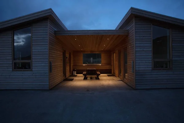 Une maison moderne en bois avec des bancs au milieu — Photo