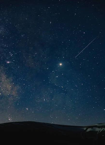 Eine schöne Aufnahme eines erstaunlichen Himmels voller atemberaubender Sterne in der Nacht über den Hügeln — Stockfoto