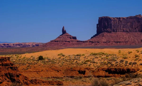 Colina del desierto con arbustos secos y acantilados en la distancia en un día soleado —  Fotos de Stock
