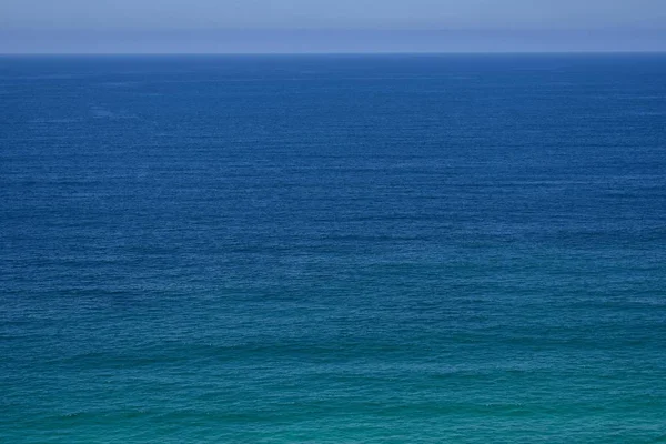 Прекрасний знімок блакитного дивовижного океану з блакитним небом на горизонті — стокове фото