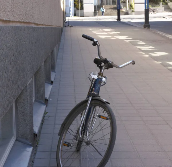 Вертикальный снимок серого велосипеда, припаркованного в пешеходной зоне возле стены — стоковое фото