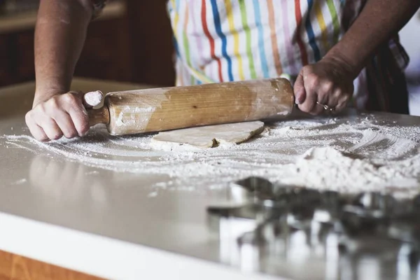 Closeup shot of a person making spreading a dough with a rolling pin — Stock Photo, Image