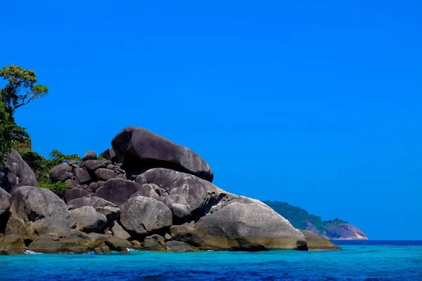 海边有一块大石头和树 背景是晴朗的天空 — 图库照片