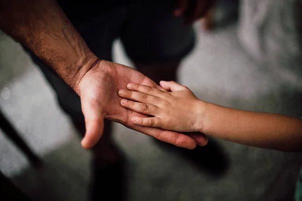 Tiro único da mão de uma criança na palma da mão de um macho — Fotografia de Stock