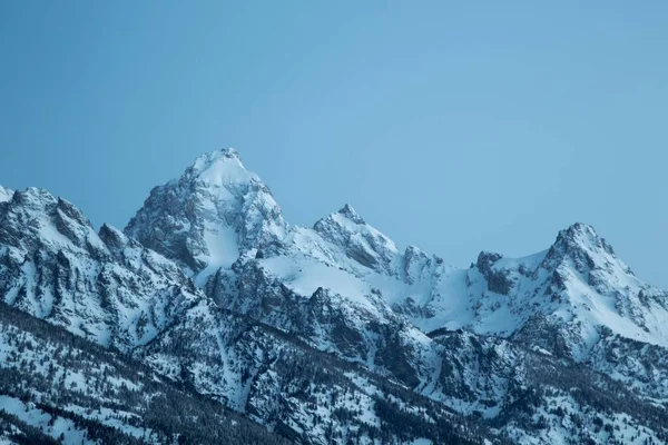 Hermosa toma de montañas cubiertas de nieve bajo un cielo azul claro —  Fotos de Stock