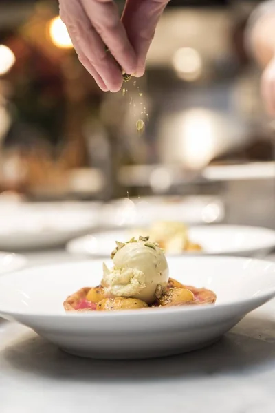 Mâna bucătarului turnând ingrediente pe un vas francez — Fotografie, imagine de stoc