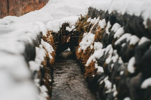 Narrow pathway between stacks of hay covered in snow — Stock Photo, Image