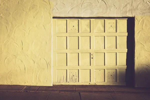 Большая белая запертая деревянная дверь и белая стена — стоковое фото
