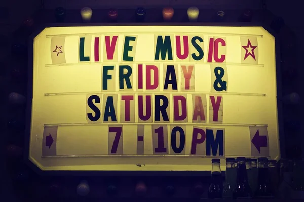 Panneau lumineux qui dit "Musique live vendredi et samedi 19h10" écrit avec des lettres colorées imprimées — Photo