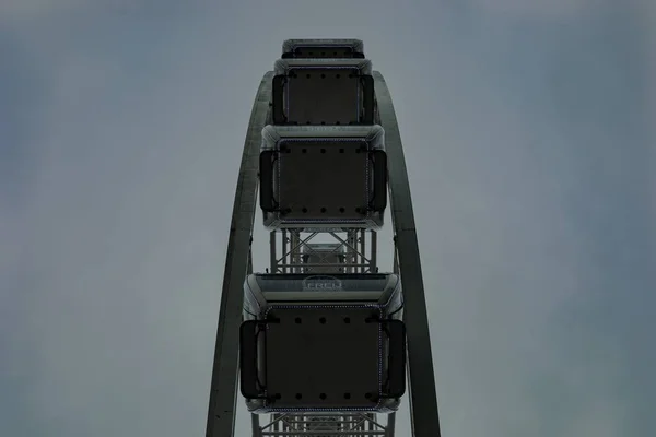 Nízký úhel symetrického záběru prázdného kola Ferris s tmavým zataživým šedým pozadím — Stock fotografie
