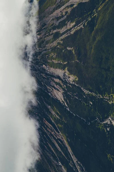 白い雲で覆われた緑の山々の垂直ショット — ストック写真