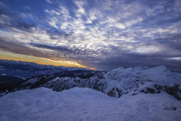 Puesta de sol en las montañas nevadas en un ambiente espectacular — Foto de Stock