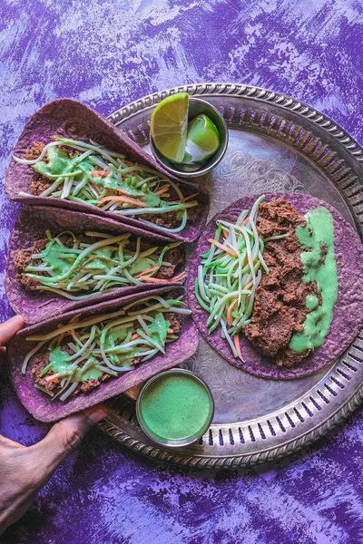 Overhead shot van Vegan taco's op een zilverplaatje en rustieke grungy paarse achtergrond — Stockfoto