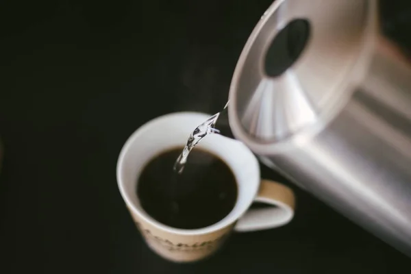 Primo piano di un caffè nero e zucchero liquido versando da un bollitore — Foto Stock