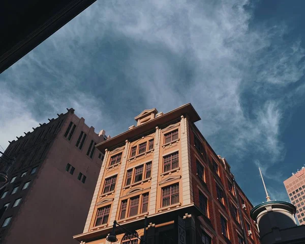 Tiro de ângulo baixo de um edifício marrom abaixo de um céu — Fotografia de Stock