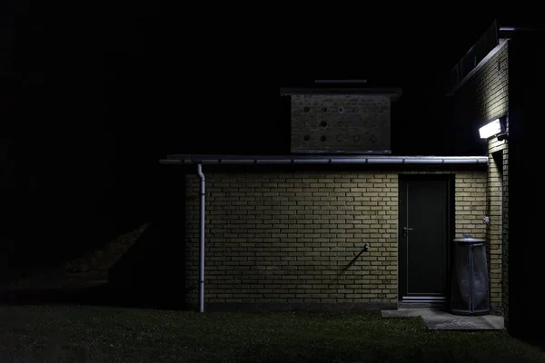 En tegelvägg förråd på natten — Stockfoto