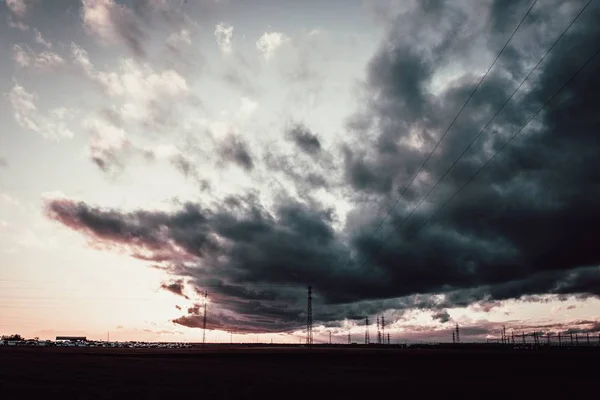 Largo tiro de un cielo nublado oscuro sobre las torres de antena. — Foto de Stock