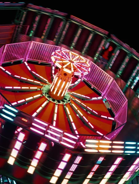 Gros plan d'un carrousel en rotation dans un parc d'attractions pendant un carnaval la nuit — Photo