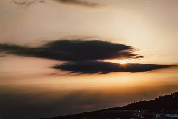 Krásný záběr oblohy a slunce svítí mezi mraky nad budovami — Stock fotografie