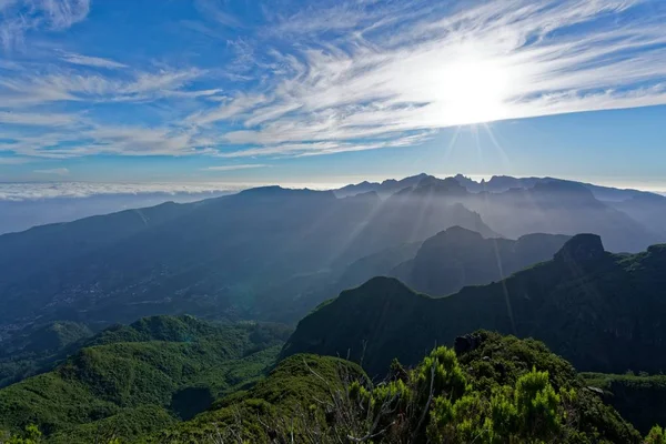 Paisagem distante tiro de colinas verdes e montanhas sob um céu ensolarado — Fotografia de Stock