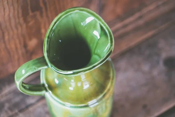 Closeup shot egy zöld kerámia Vintage váza egy fából készült háttér — Stock Fotó