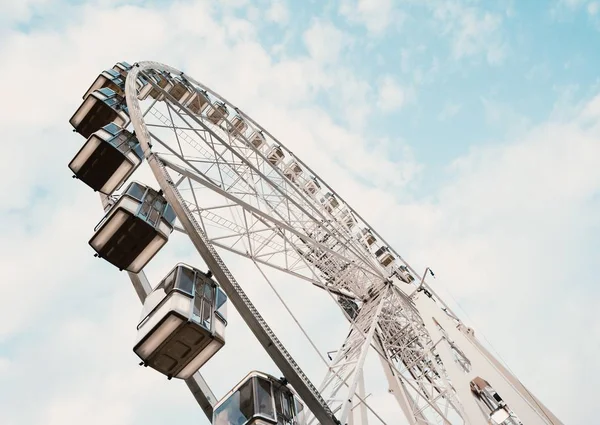 Low angle shot of a Ferris wheel with cloudy blue sky in the background — Stock Photo, Image