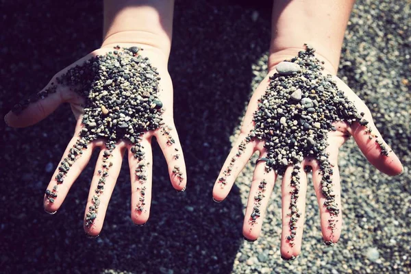 Closeup shot of small pebbles on hands — Stock Photo, Image