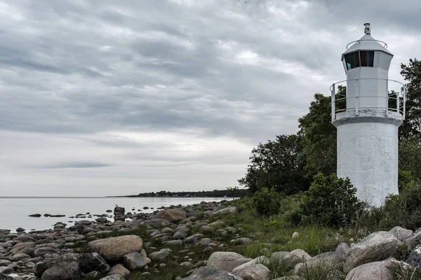 Tournage de la belle côte rocheuse de la mer avec une tour de phare blanc sur le côté — Photo