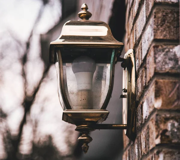 Shallow closeup shot of a street lantern on a stone wall