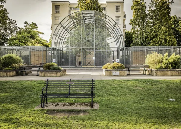 Hermosa toma de un parque con un banco en la hierba — Foto de Stock