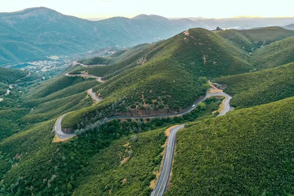 Воздушный Снимок Красивых Зеленых Холмов Гор Узкой Извилистой Дорогой Посередине — стоковое фото