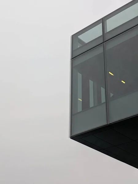 Tiro vertical de baixo ângulo de um edifício preto alto com janelas de vidro — Fotografia de Stock