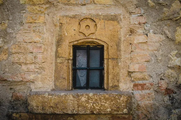 Primo piano colpo di una finestra chiusa su un muro di pietra gialla — Foto Stock