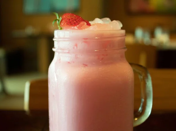 Крупним планом смачно-рожевий полуничний молочний коктейль з розмитим тлом — стокове фото