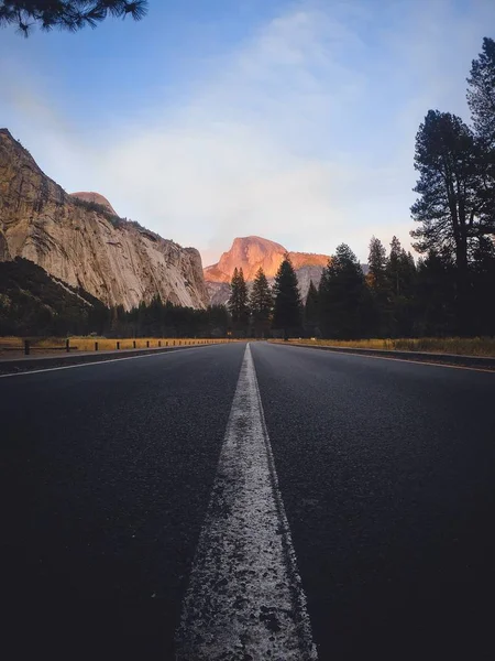 Carretera vacía en medio del bosque con cielo azul en Yosemite, CA . — Foto de Stock