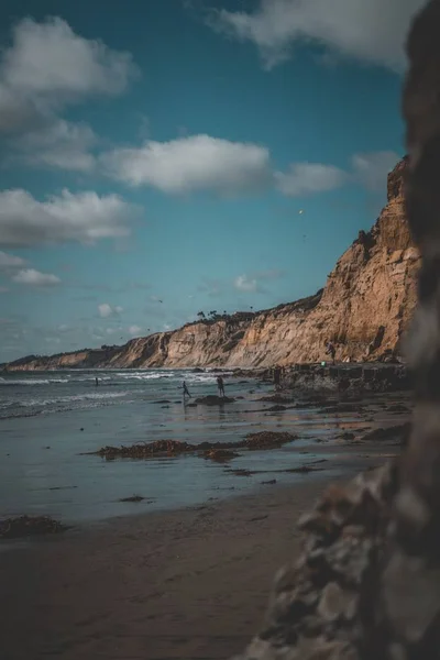 Een Paar Mensen Rennen Het Strand Met Rotsachtige Bergen Lucht — Stockfoto