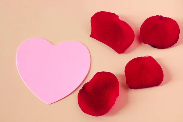 Coração rosa com pétalas vermelhas — Fotografia de Stock