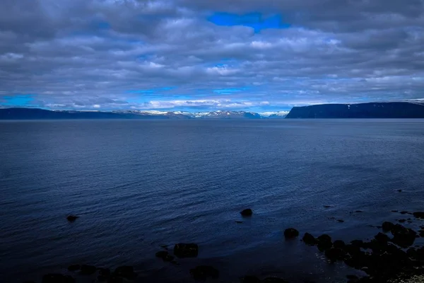 Piękne Ujęcie Morza Gór Oddali Pod Chmurnym Niebem — Zdjęcie stockowe