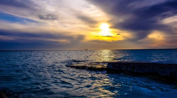 Hermosa toma de un mar que refleja la luz del sol bajo un cielo nublado — Foto de Stock